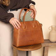 Styled Fit Perspective of Marsala Full-Grain Leather Handbag for Kvinner on Model - Natural Daylight Drape
